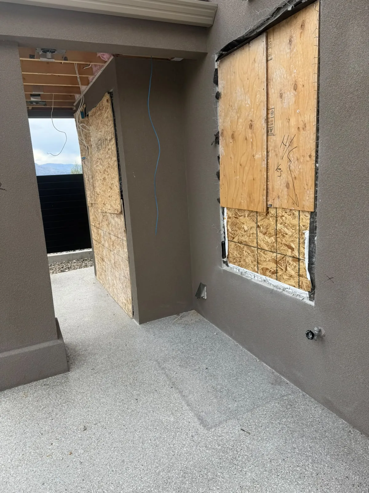 Wire lath and boarded openings prepped for stucco on a home exterior.