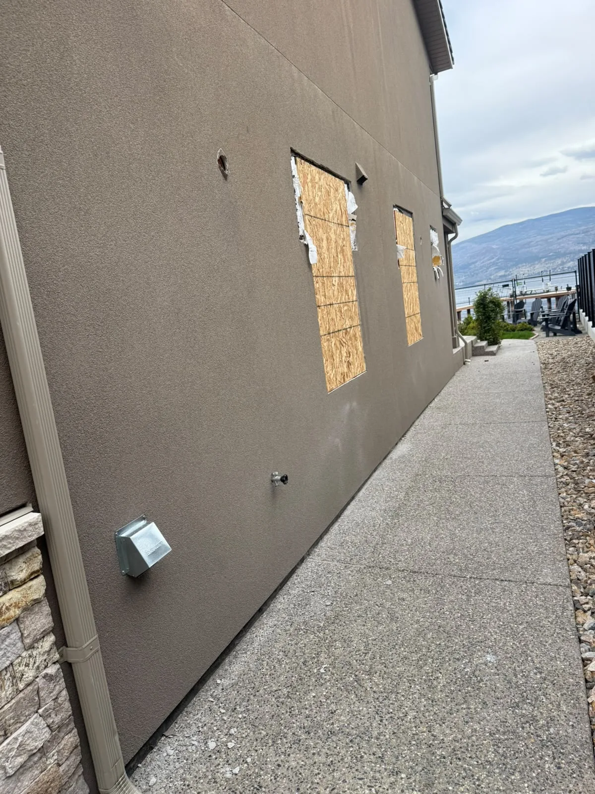 Window openings cut back in an existing stucco wall before repair.