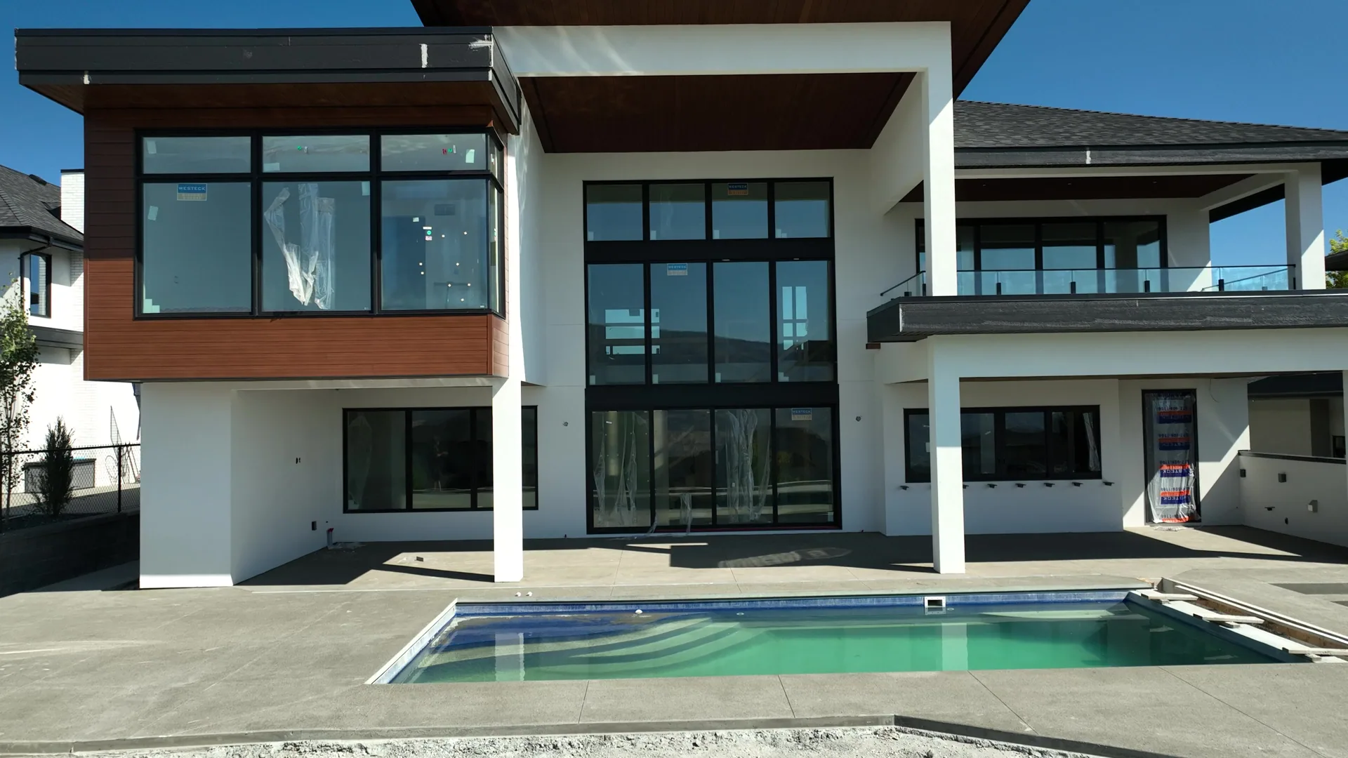 Stucco home with a wraparound porch above the lake.