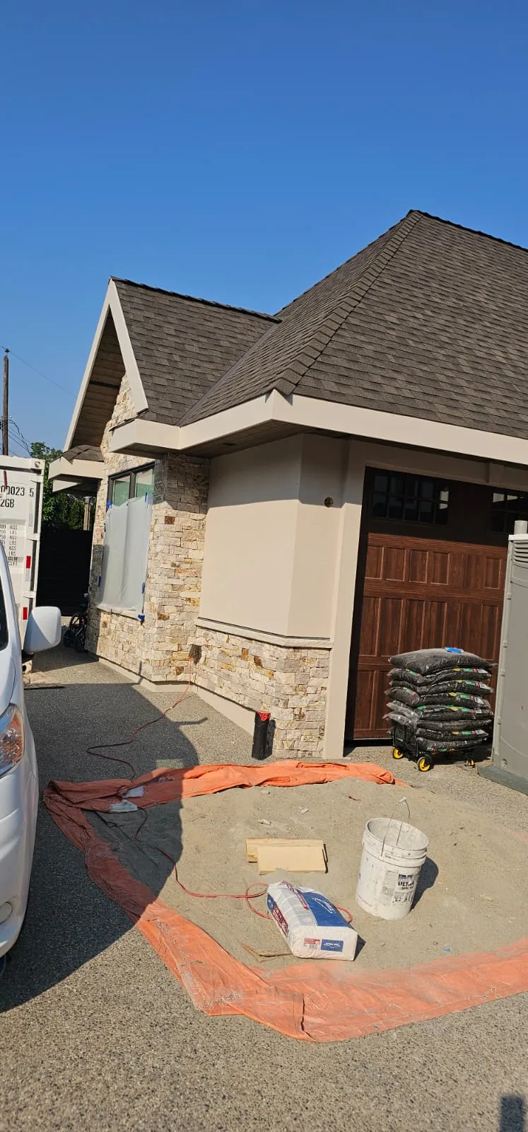 Materials and drop sheets set up in the driveway before a stucco lift.