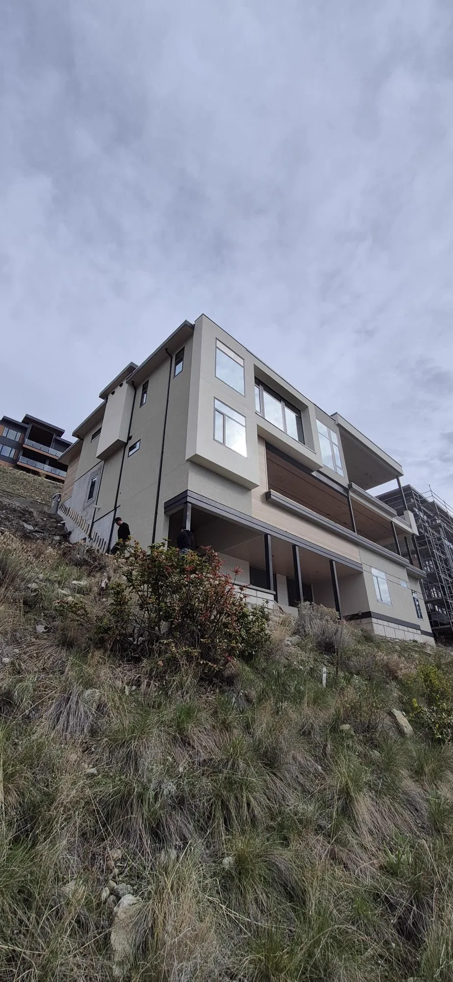 Crew working the exterior of the Arrowroot Drive home on a steep, tight site.